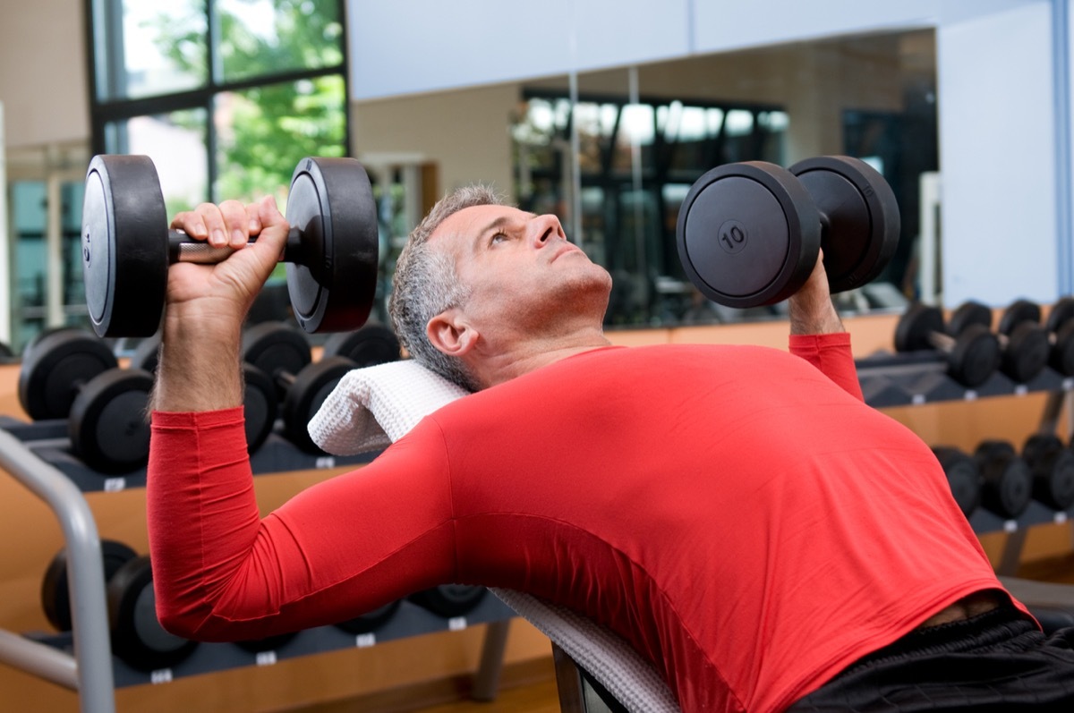 middle aged white man lifting weights at the gym