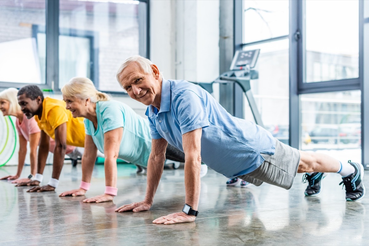 group of seniors doing planks at the gym