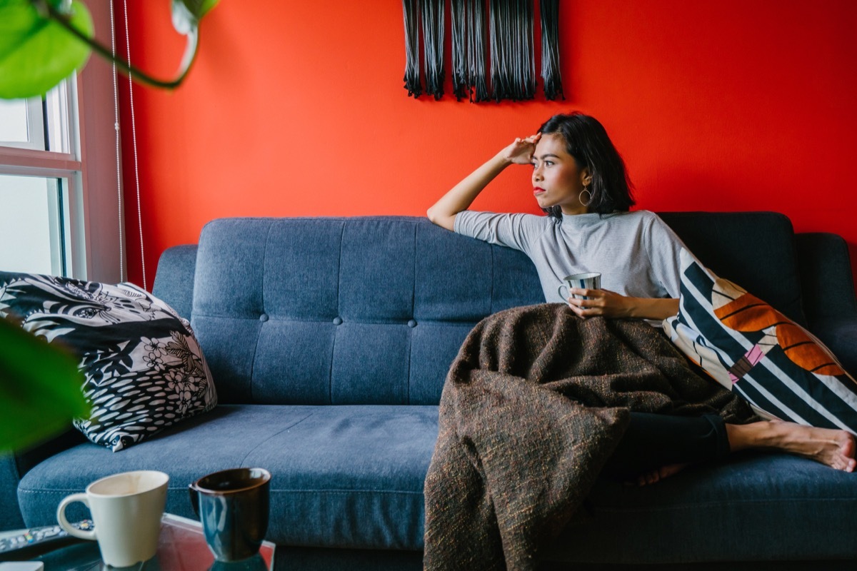 Woman looking out the window on a couch