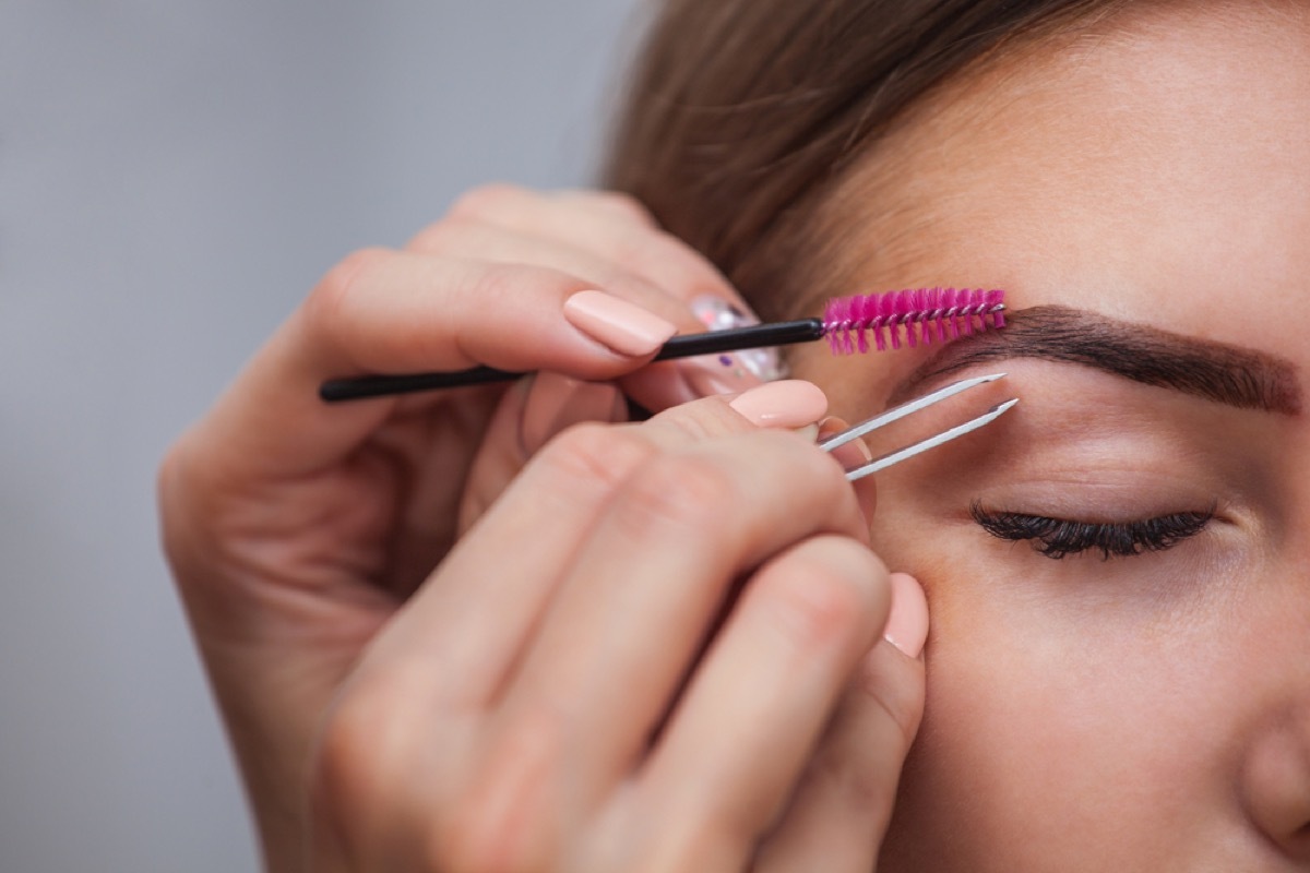 woman plucking eyebrow, female friend