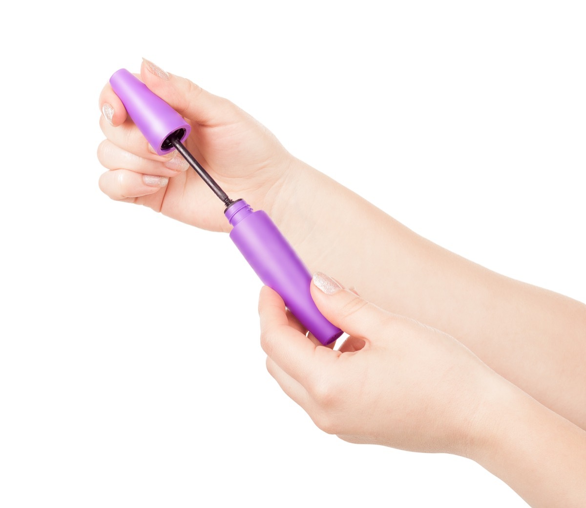 woman opening mascara tube, using objects wrong