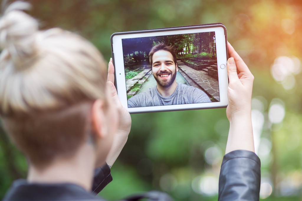 couple facetimes in park dating coronavirus