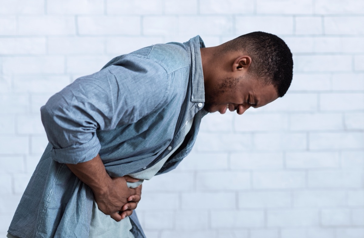 young man bent over with stomach pain