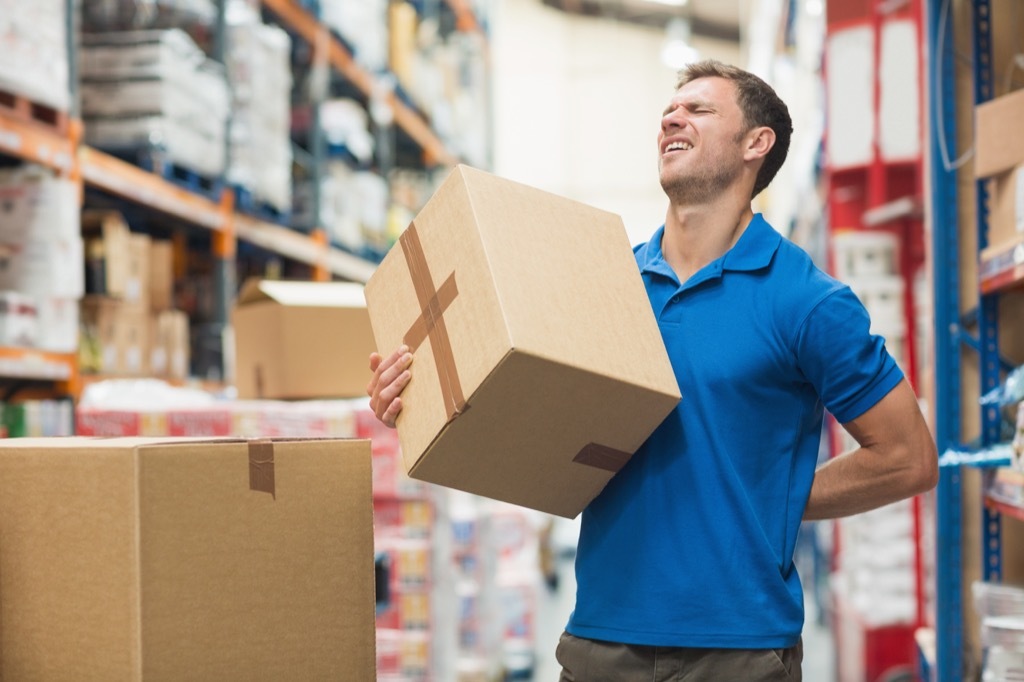 man lifting a box in a warehouse got hurt