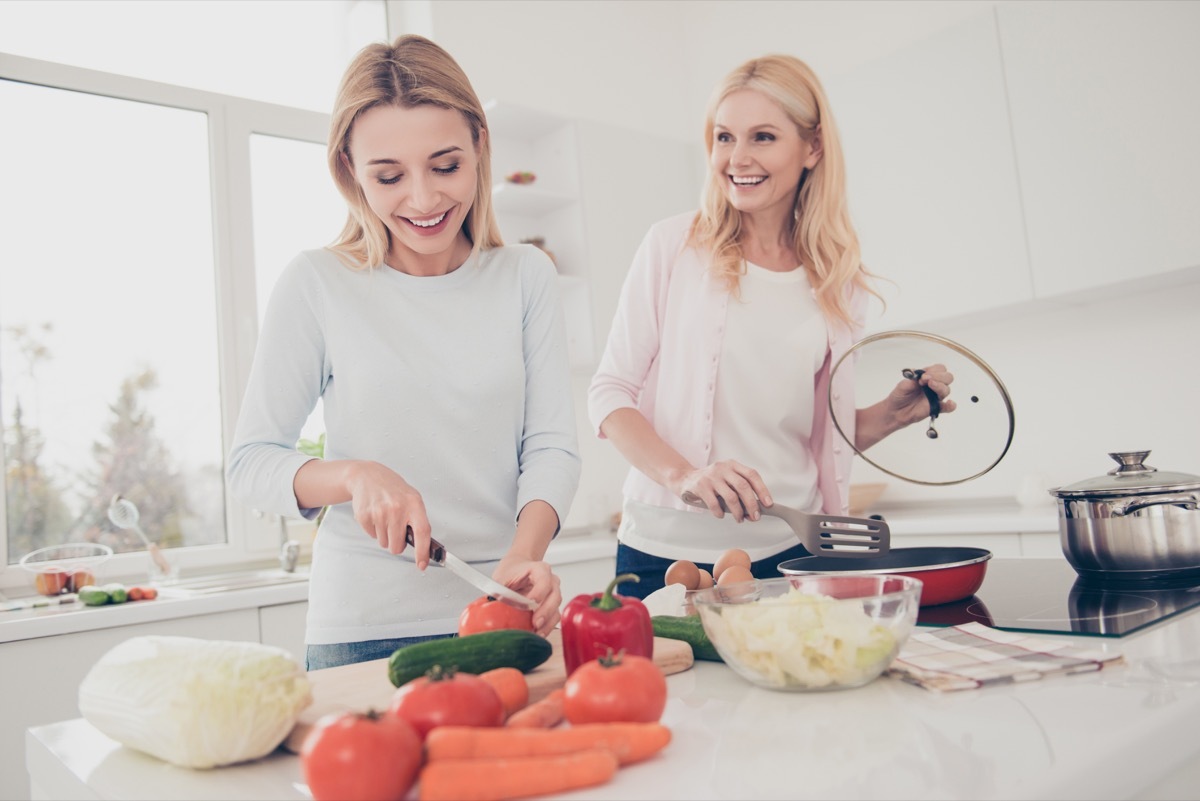 white mother and dinner cooking together