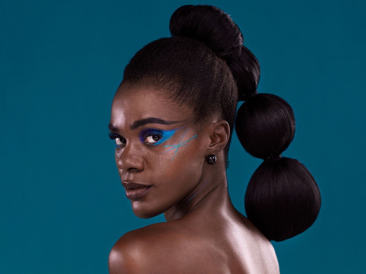 Studio portrait of a beautiful young woman posing against a turquoise background