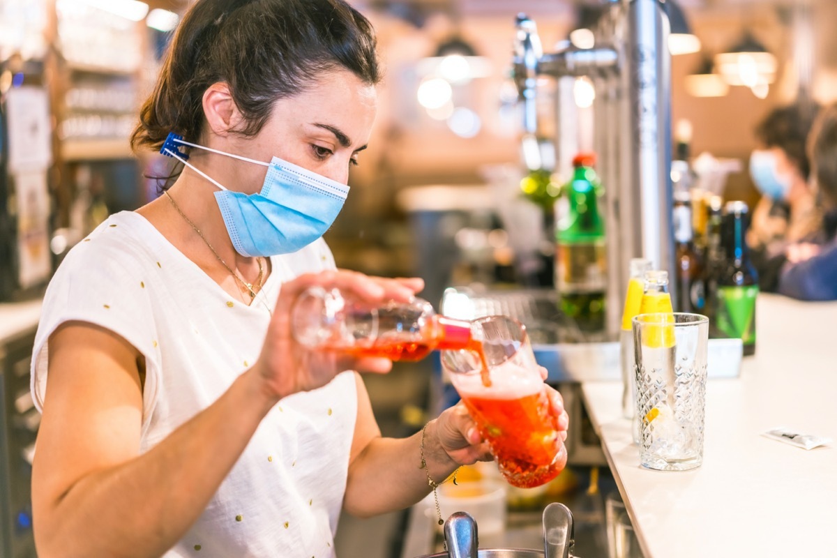 waitress with a face mask in a bar.