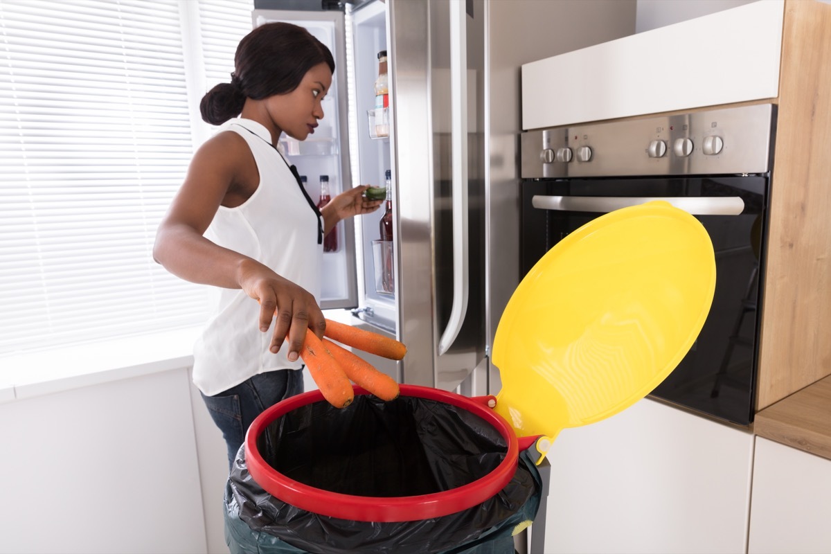 Woman Throwing Carrot In Trash Bin