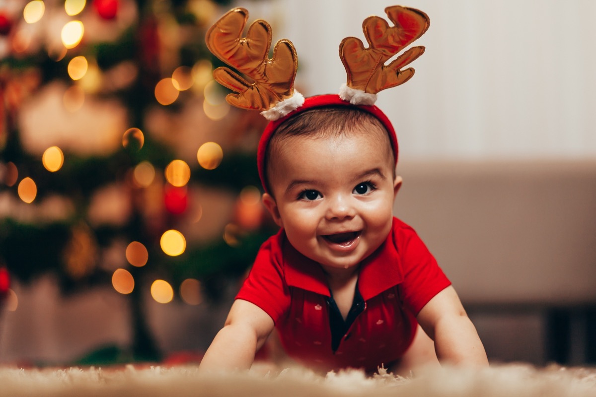 hispanic baby in reindeer ears crawling