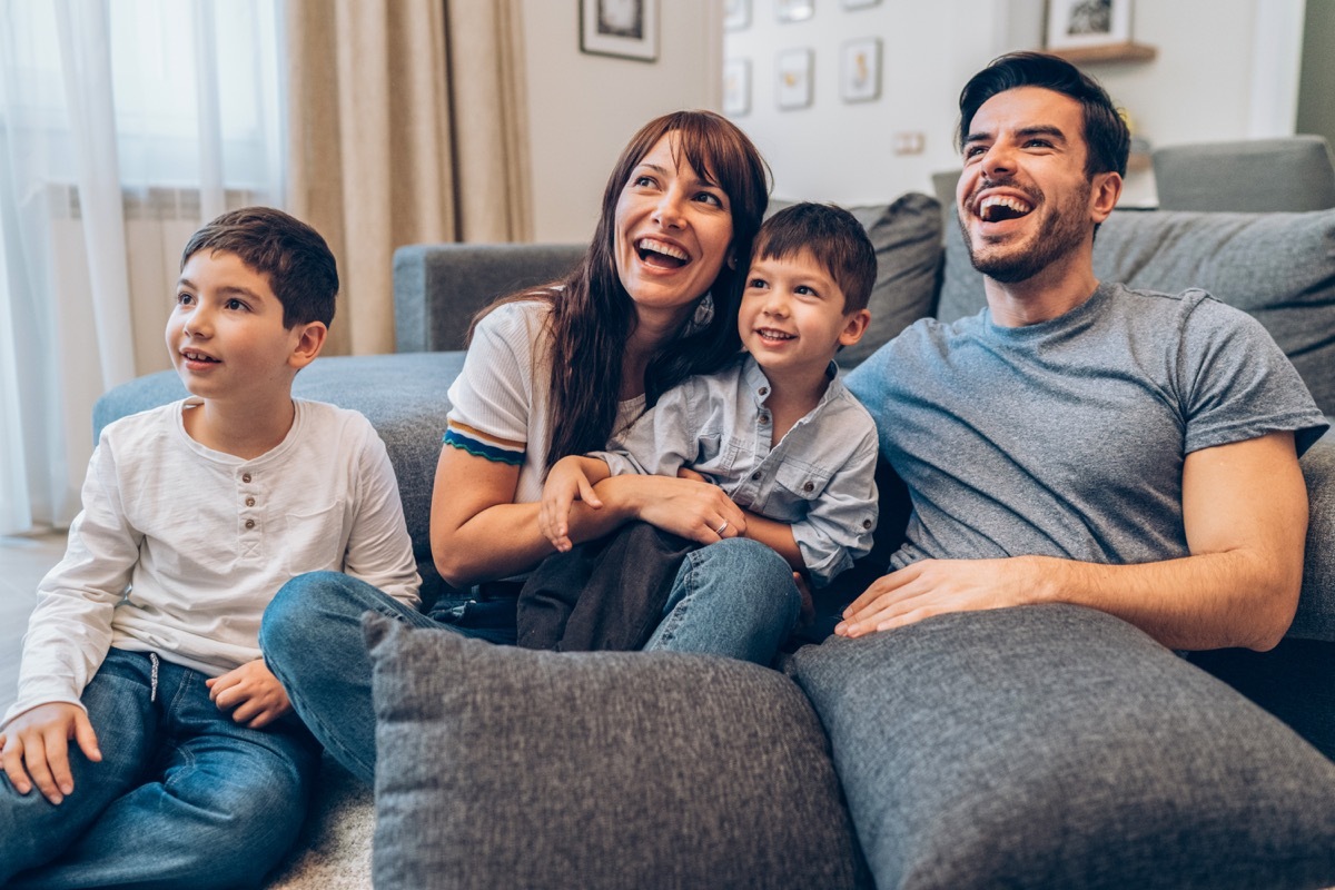 family relaxing while one child is sitting further away