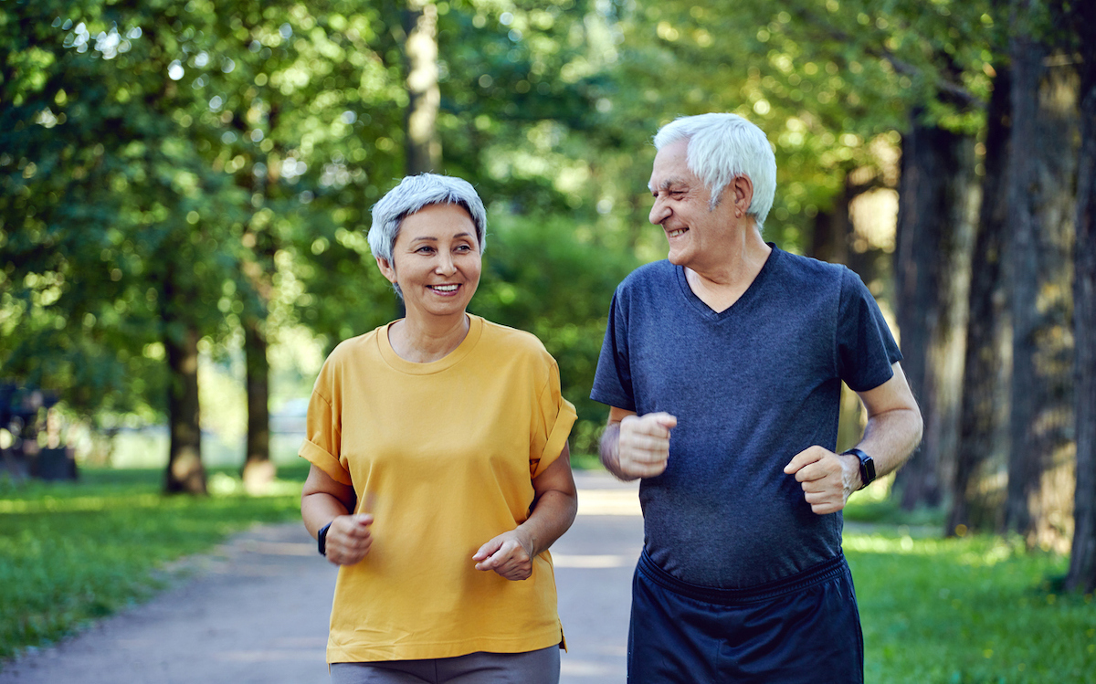 A happy senior couple taking a walk in the park on a sunny day.