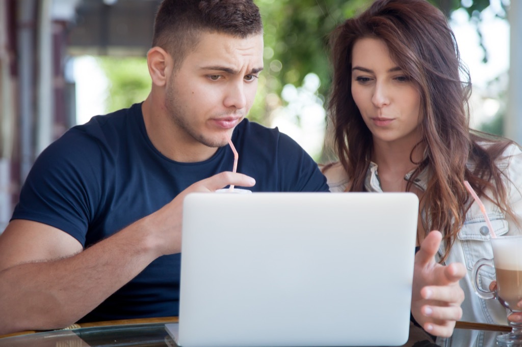 woman and man looking at computer shocked