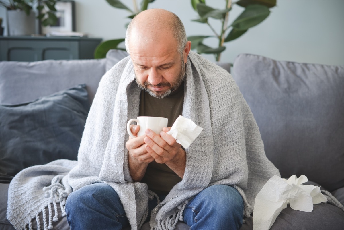 sick man sitting on a sofa in the room