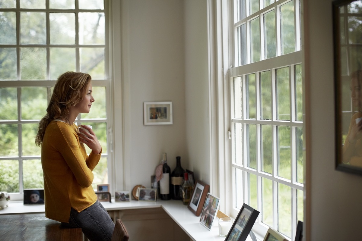 woman looking out the window and thinking