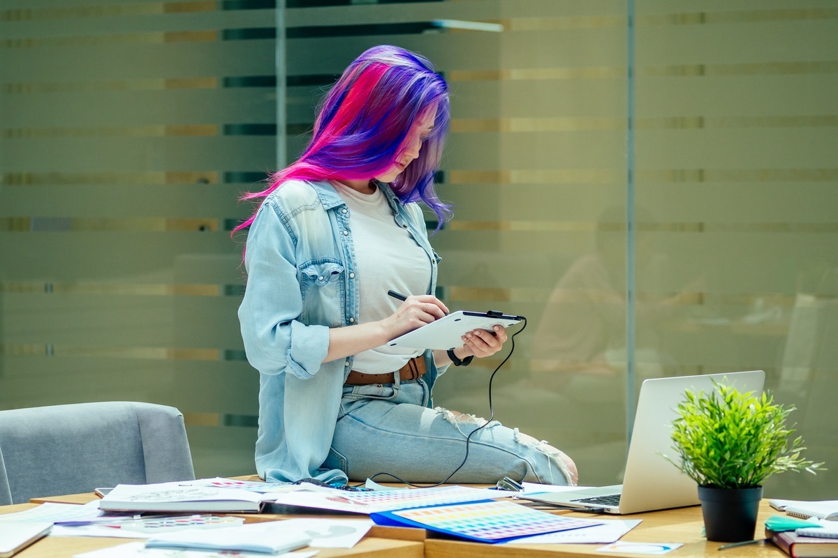 woman with colorful hair wearing ripped jeans